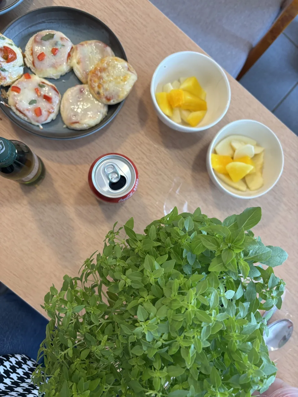 Mini pizzas caseiras com potinhos de fruta picada ao lado