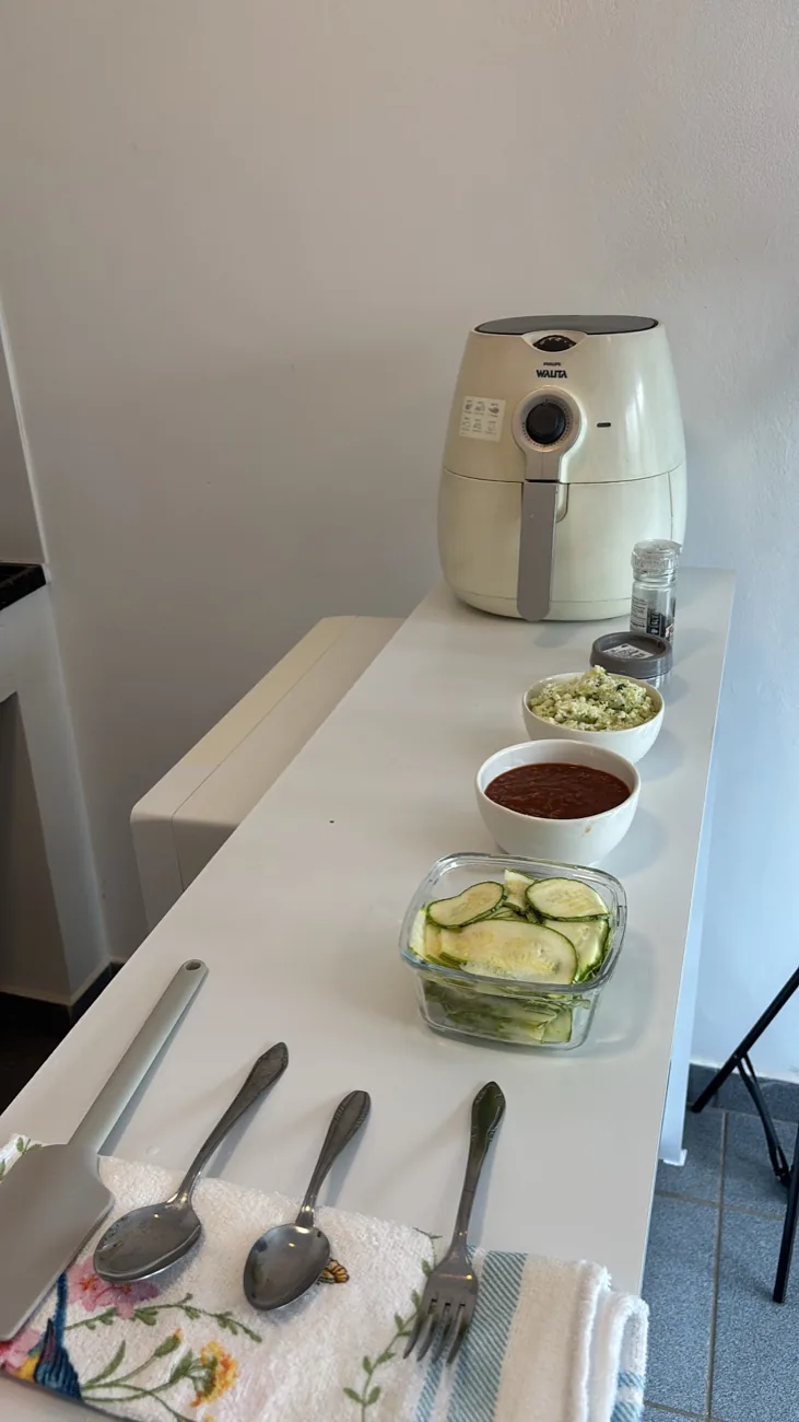 Abobrinha fatiada, molho e recheio prontos ao lado da air fryer